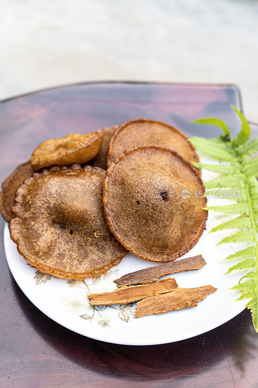 它是孟加拉国和印度人的一种流行食物。这种物品在孟加拉国被称为tele vaga pitha。它是如此美味。这种食物是由米粉、糖和油制成的。
